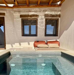 AggelikaにあるConte Mykonos IIの窓のある客室で、スイミングプール(ソファ付)を利用できます。