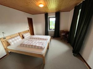 a bedroom with two beds and a window at Gasthaus zur Heide am Nürburgring in Welcherath