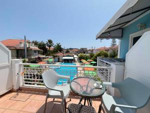 a balcony with a table and chairs and a swimming pool at HELEN STUDIOS in Planos