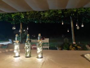 a table with three wine bottles with lights on it at l'envie d'ailleurs in Malmedy