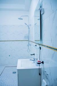 ドゥアラにあるServices Meubléの洗面台と鏡のある白いバスルーム