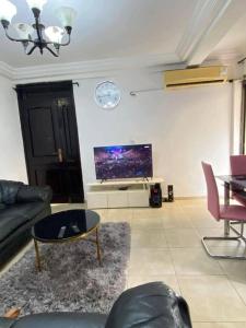 ドゥアラにあるServices Meubléのリビングルーム(ソファ、壁掛けテレビ付)