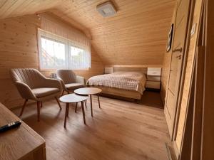una piccola camera con un letto e due sedie e un tavolo di Domek Willa Garden a Ustronie Morskie