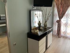 a dressing table with a mirror and vases on it at Alexandra Luxury Apartment in Alexandroupoli