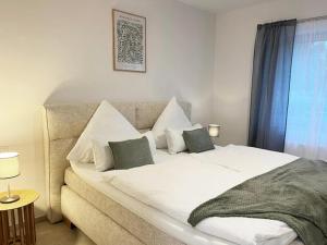 Una cama blanca grande en una habitación con ventana. en Exklusive Wohnung mit Ahrblick 3, en Bad Neuenahr-Ahrweiler