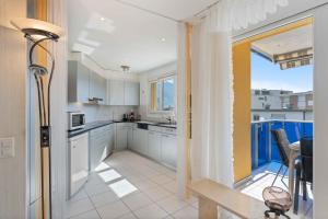 a kitchen with white cabinets and a large window at Casa Verbanella - Objekt 7500 in Minusio