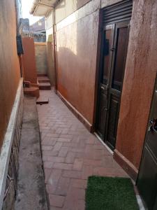 an empty hallway with a door and a green rug at muffler motel bukesa in Kampala +10 photos