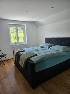 a bedroom with a large bed with a window at Appartement Traunsteinblick in Weberstorf