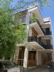 a white house with a car parked in front of it at De Khar Guest House in Leh +19 photos