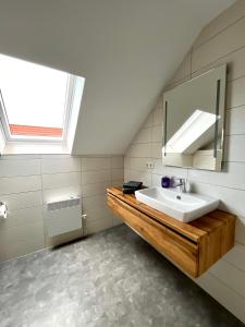 une salle de bain avec un lavabo et un miroir dans l'établissement Ferienhaus Hexenpfad Bettw Handtücher inklusive, à Hasselfelde