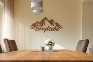 a table with a vase of flowers and a sign on the wall at Hotel Bergkristall in Willingen