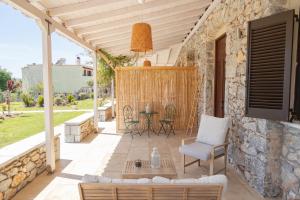 a patio with a stone wall and a table and chairs at Sophia Areopoli Town Square in Areopoli