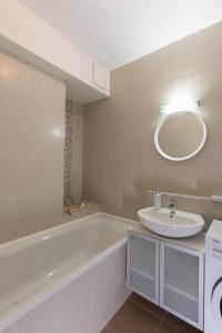 un bagno con vasca, lavandino e specchio di Sunset Resort 107 a Fonyód