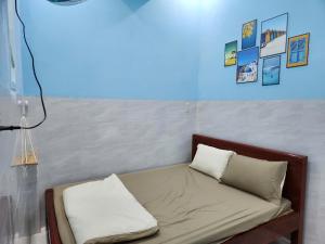 a bed in a room with pictures on the wall at Dan Family Homestay in Ấp Bình Hưng +24 photos