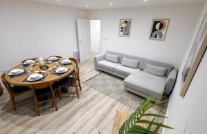 ein Wohnzimmer mit Tisch und Couch in der Unterkunft Stylist 2-Bedroom Flat - Watford Central in Watford