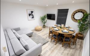 ein Wohnzimmer mit Sofa und Tisch in der Unterkunft Stylist 2-Bedroom Flat - Watford Central in Watford