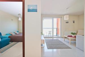a bedroom with a bed and a living room with a couch at Apartamenty Przymorze in Gdańsk