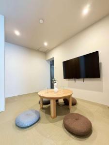 a living room with a table and a flat screen tv at Celine Kanayama by b hotel - Central 2BR 2 Baths Vibrant Area & Shopping 51 in Hiroshima