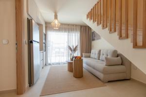 ein Wohnzimmer mit einer Couch und einer Treppe in der Unterkunft Anna Luxury Villas by RentalsPro - Nea Flogita Halkidiki in Flogita
