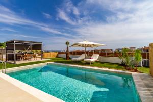 ein Swimmingpool auf dem Dach eines Gebäudes mit einem Sonnenschirm in der Unterkunft Anna Luxury Villas by RentalsPro - Nea Flogita Halkidiki in Flogita