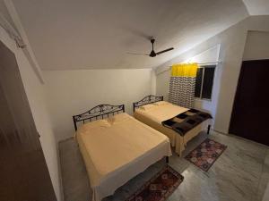 two beds in a small room with a window at Spacious 3 BHK Villa, Lonavala in Lonavala