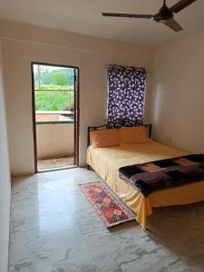 a bedroom with a bed and a large window at Spacious 3 BHK Villa, Lonavala in Lonavala +13 photos