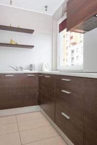 a kitchen with brown cabinets and a window at Apartamenty Przymorze in Gdańsk