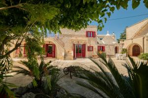 a large stone building with red shutters on it at Masseria Trulli Bruni in Locorotondo