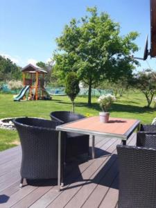 a table and chairs on a deck with a playground at Domki z bali Polanica-Zdrój in Polanica-Zdrój