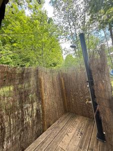 un patio trasero con una valla y una terraza de madera en Tente Lodge en pleine nature, en Cros