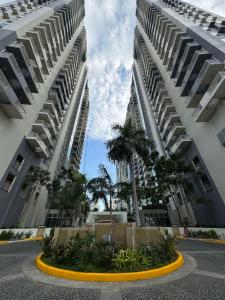 two tall buildings with palm trees in a courtyard at Reign Escape in Manila +16 photos