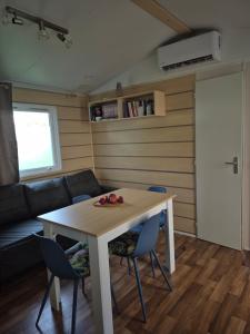 a room with a table and chairs and a couch at narbonne plage camping Marvilla in Narbonne-Plage