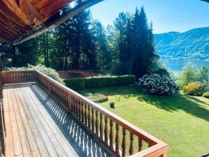 a wooden deck with a view of a lake at Landhaus Lärchenhof Luxury Apartments in Sattendorf