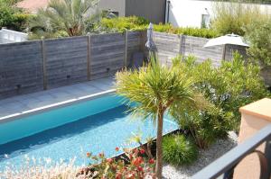 a garden with a swimming pool and a fence at La Belgerie in La Bernerie-en-Retz
