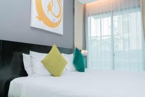 a bedroom with a bed with two pillows and a window at Beachfront Family Pool 1 BR 1 Living Patong Phuket in Patong Beach