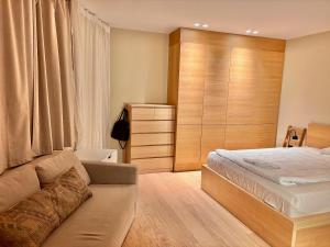 a bedroom with a bed and a couch at The Wooden House, Spacious, garden, new and modern in Oslo +41 photos