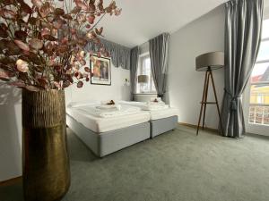 a bedroom with two beds and a vase with flowers at Landgasthof Alter Wirt in Unterschleißheim