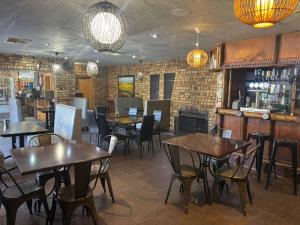 a restaurant with tables and chairs and a bar at Leach Lodge in Kuruman