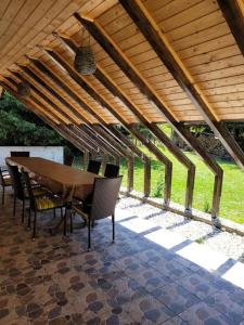 a wooden table and chairs under a wooden roof at Forest-House in Praid