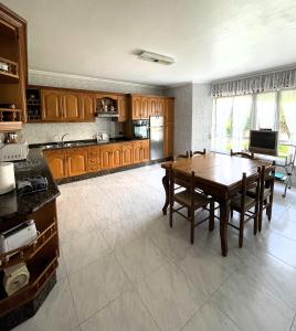 a kitchen with a wooden table and a dining room at EnVIVEIRO Villa Bonita in Viveiro +24 photos