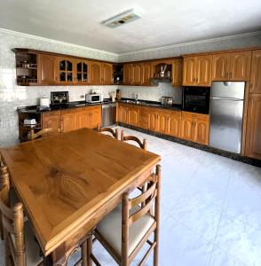 a kitchen with a wooden table and a refrigerator at EnVIVEIRO Villa Bonita in Viveiro