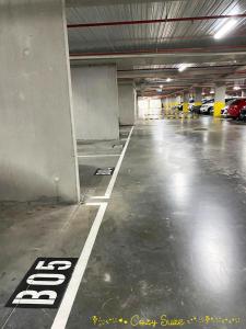 an empty parking garage with cars parked in it at Cozy Suite in Clayton North