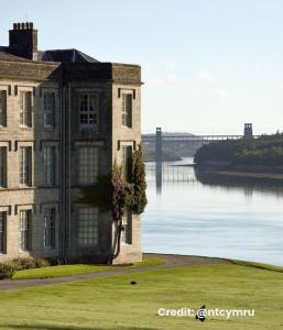 ein altes Gebäude neben einem Wasserkörper in der Unterkunft Charming, stylish cottage, parking , large private Garden, well located for island highlights in Gaerwen + 36 Fotos