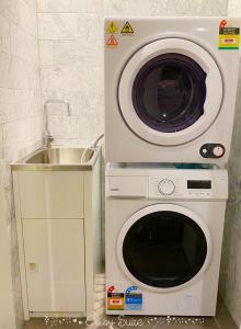 a washing machine and a sink in a kitchen at Cozy Suite in Clayton North