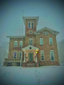 a large brick building with snow on the ground at Graystone Manor in Albion