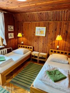two beds in a room with wooden walls at Maple House - Sodyba Tarp Klevų in Utena +10 photos