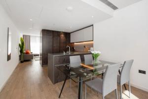 a kitchen with a glass table and chairs at Modern 2 Bed Battersea Power Station in London