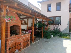 a brick patio with a brick fireplace in front of a house at Casa Teo in Ocna Sibiului