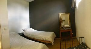 a small bedroom with two beds and a mirror at appartement op de begane grond met terrasje in Groesbeek