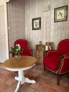 a table with two chairs and a vase with flowers at La Reboursière in Notre-Dame-du-Pé +10 photos